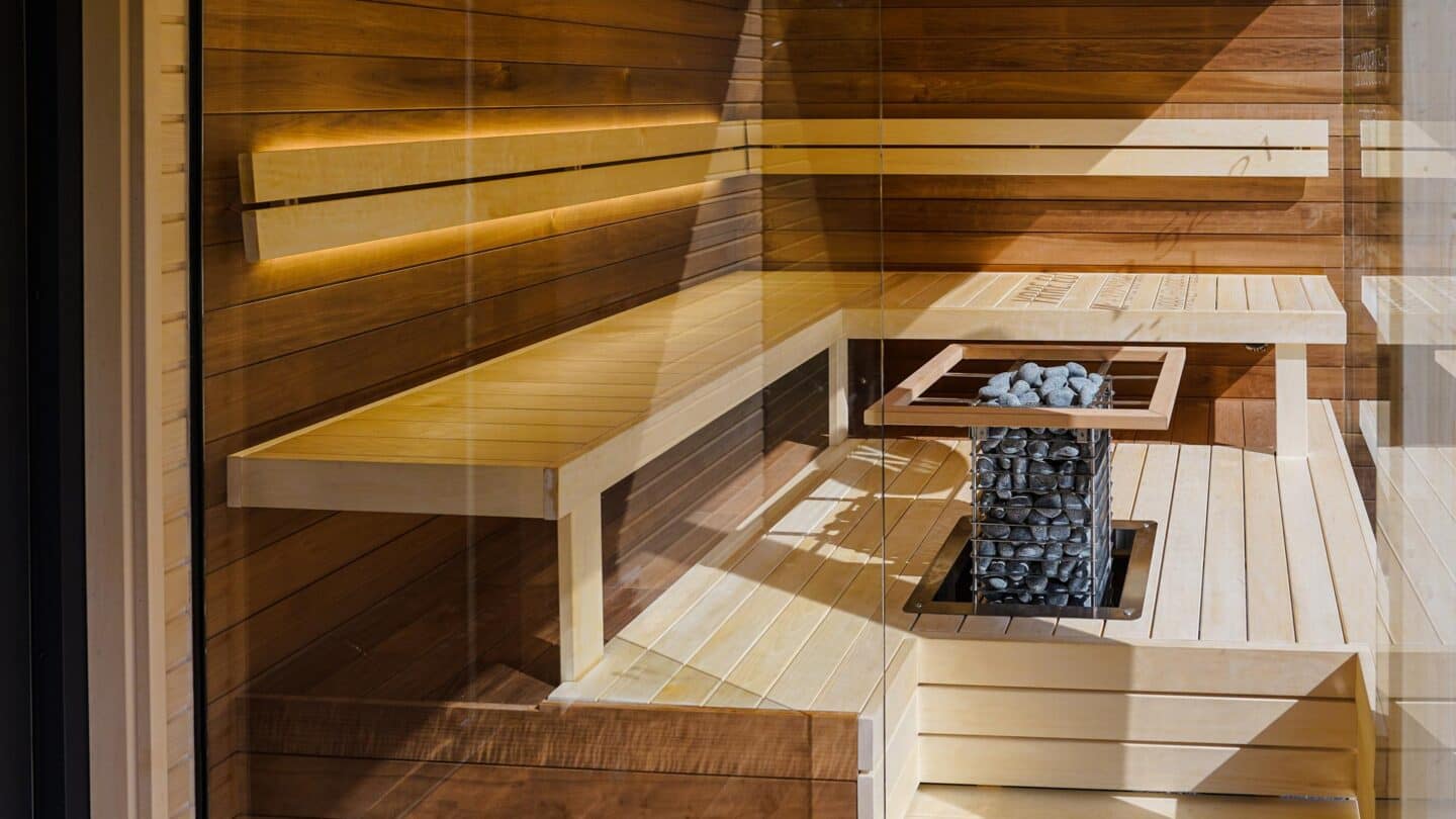 A HUUM CLIFF set into an opening in the middle of pale wood benches behind glass