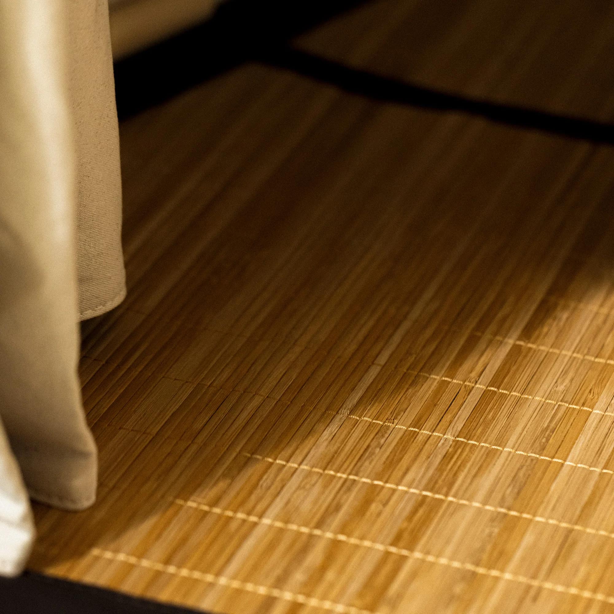 Corner of the FireLight's bamboo floor mat beside the canvas enclosure wall