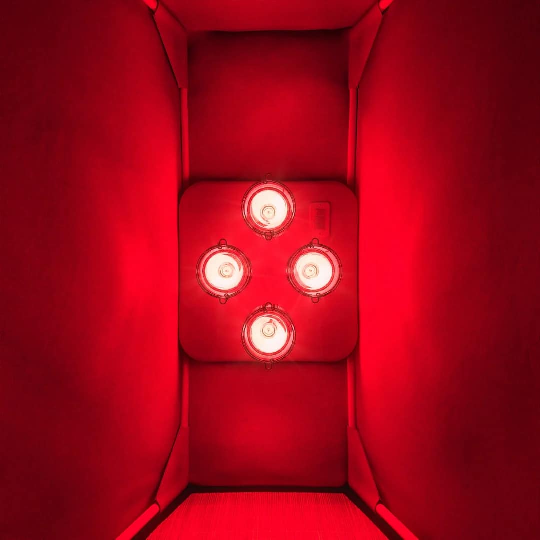 Looking down into a FireLight enclosure at the four-bulb Hearth panel glowing against red walls