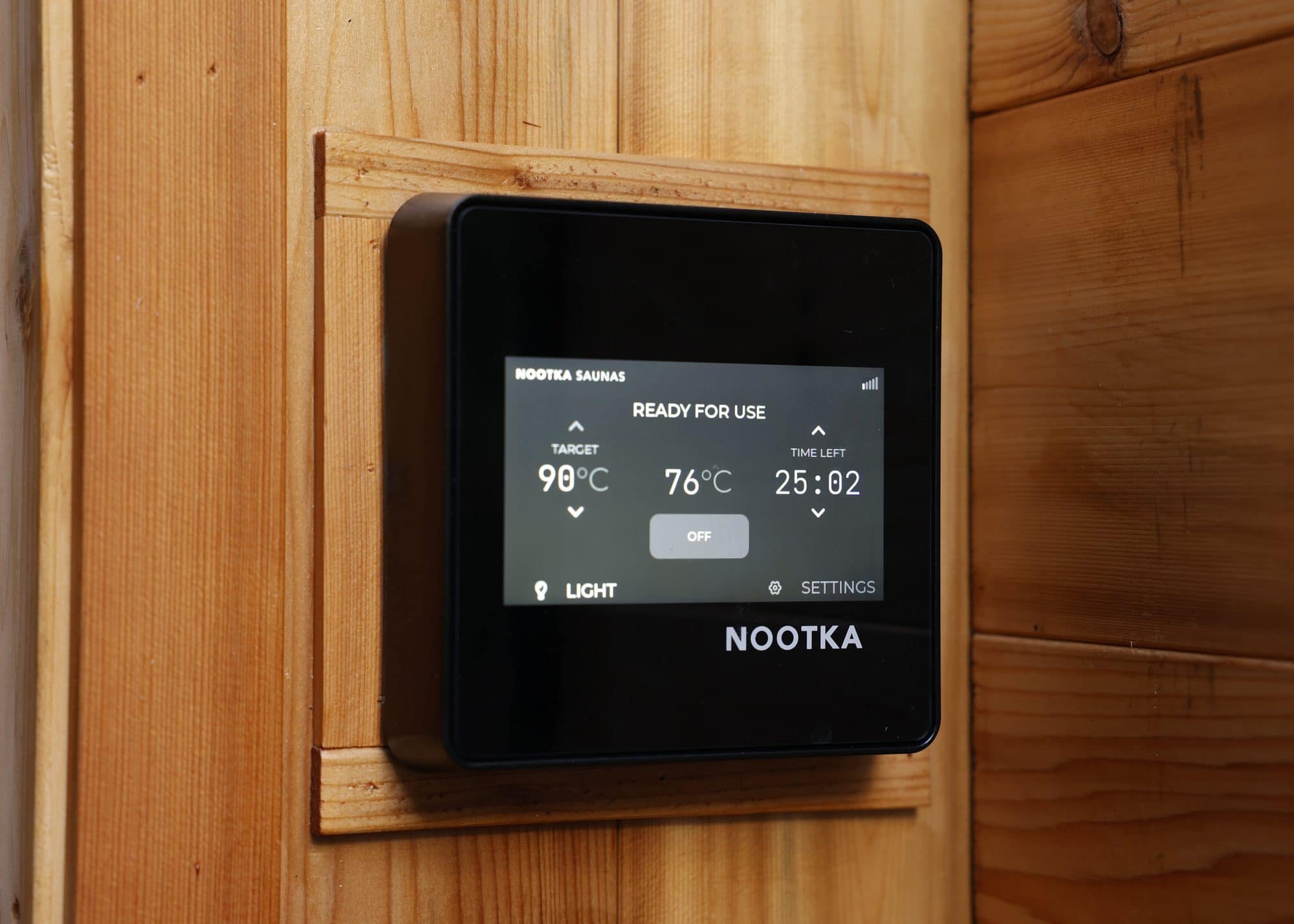 The Nootka touchscreen controller on a cedar wall reading ready for use, set to 98°C with the room at 76°C