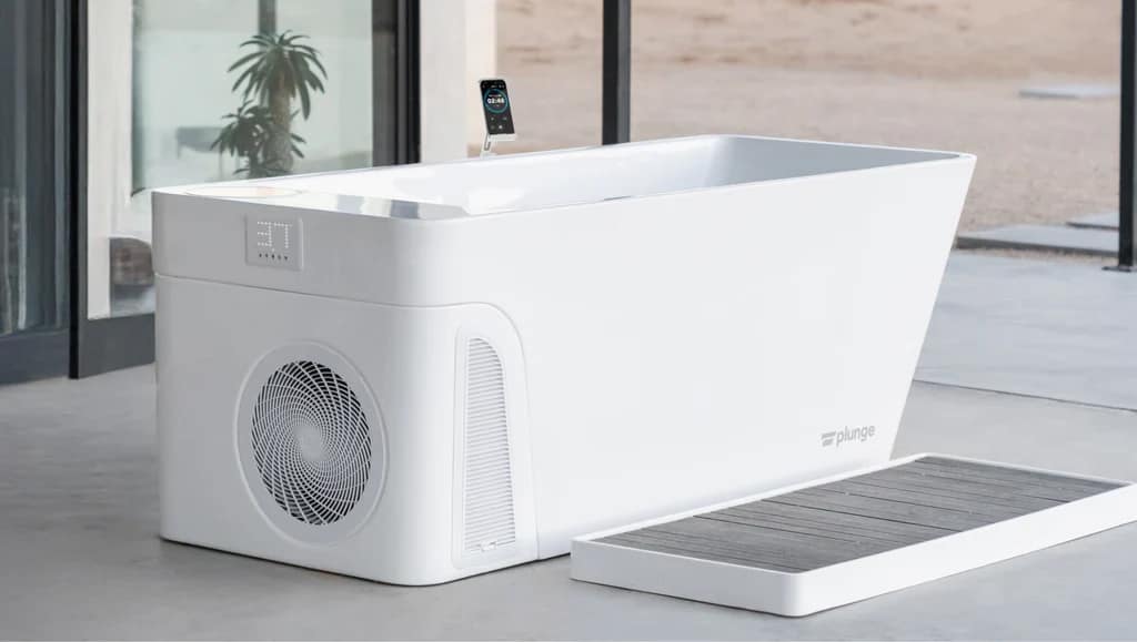 A Plunge All-In with its built-in chiller and a slatted step mat on a concrete floor by a window